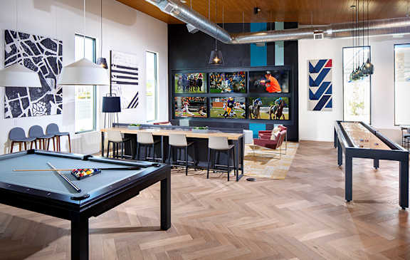 A room with a pool table and a foosball table.