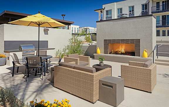 A patio with a table, chairs, and a fireplace.