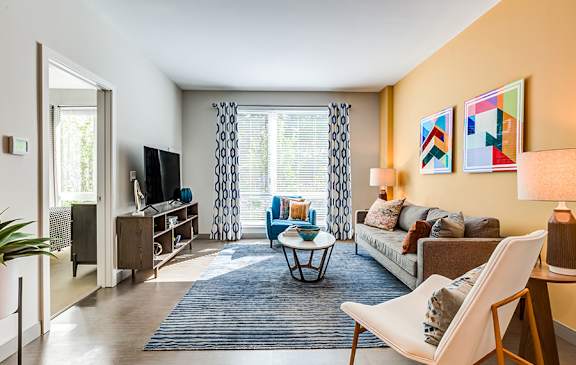 A living room with a white chair and a blue couch.