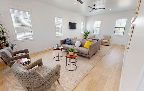 A living room with a grey couch, a patterned armchair, and a coffee table.