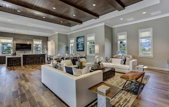 A modern living room with a white sofa set and a wooden coffee table.