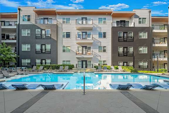 A large apartment complex with a pool in the middle.