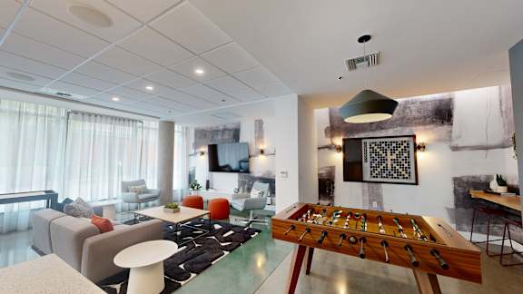 A game of checkers is set up on a wooden board in the middle of a modern living room.