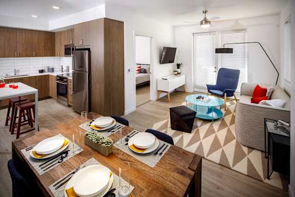 A modern kitchen with a dining table set for two.
