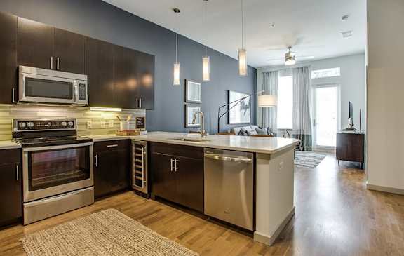 A modern kitchen with dark wood cabinets and stainless steel appliances.