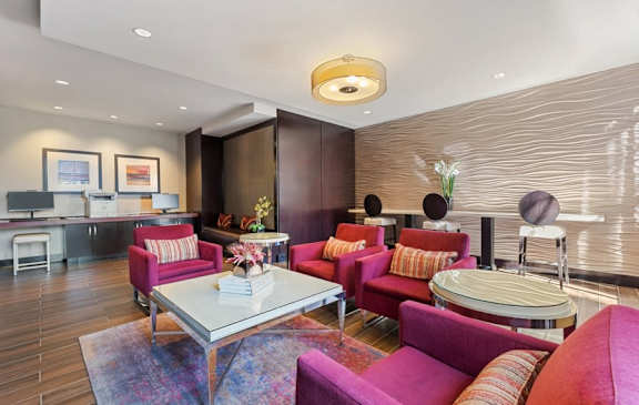 A living room with a glass table and red couches.
