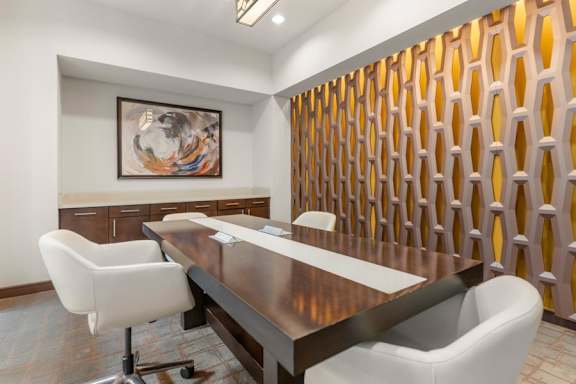 A conference room with a long table and chairs.