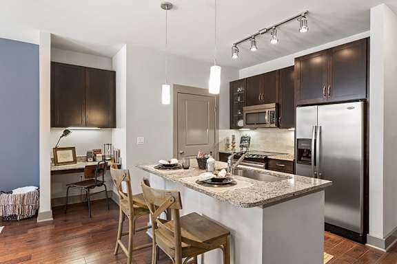 A kitchen with a table and chairs.