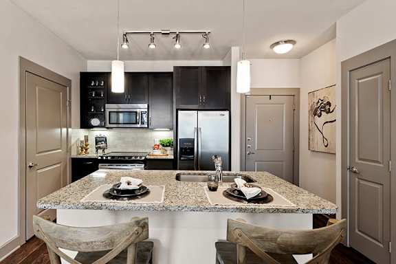 A kitchen with a granite countertop and a refrigerator.