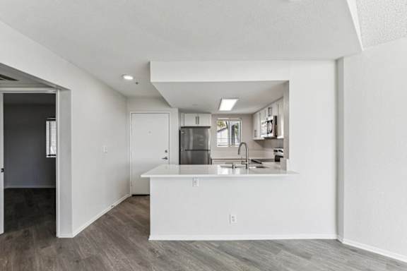 A kitchen with white cabinets and a white island.