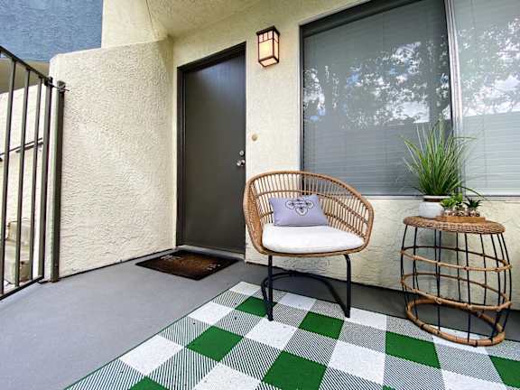 a front porch with a chair and a side table