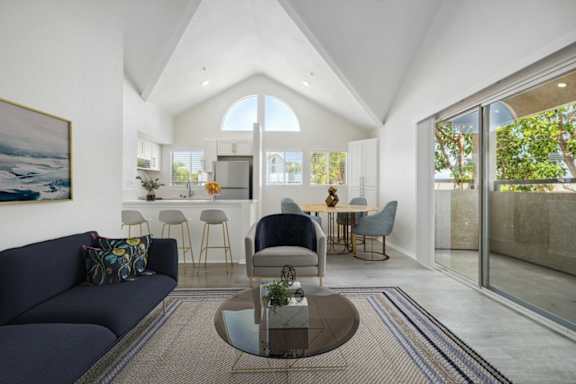 A modern living room with a dark blue sofa and a glass coffee table.