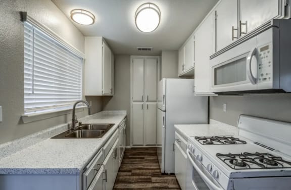 a white kitchen with white appliances and white cabinets at Aspire Seneca, Victorville, 92392