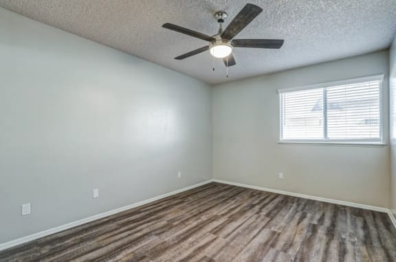an empty bedroom with a ceiling fan and a window at Aspire Seneca, Victorville, California