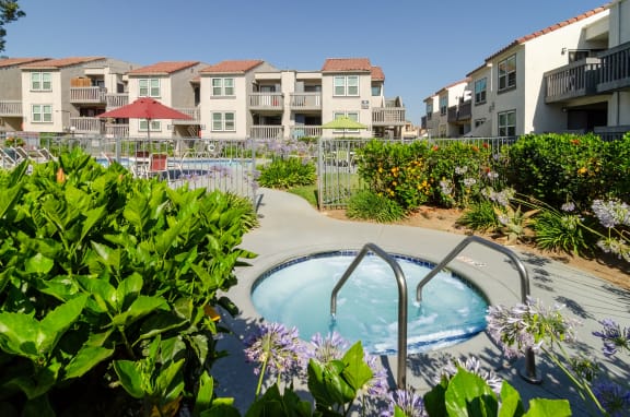 a jacuzzi tub in a garden with apartments in the background at Aspire Corona, Corona, California