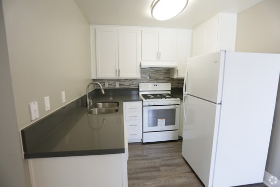 a kitchen with white appliances and white cabinets at Encore Apartments, Ontario, 91764