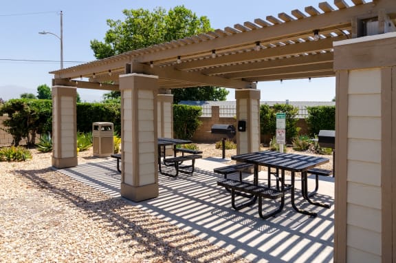 a picnic area with a table and benches under a pergola at Aspire Rialto, Rialto, CA, 92376