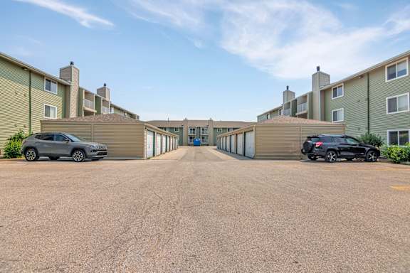 Parking lot with garage units and apartment buildings at Winding Hills Apartments, Davenport, IA 52807