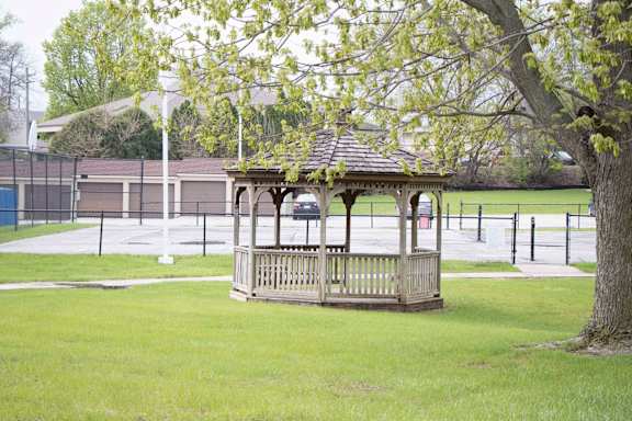 A wooden gazebo sits in a grassy field. at Indian Ridge Apartments, Davenport, IA, 52807