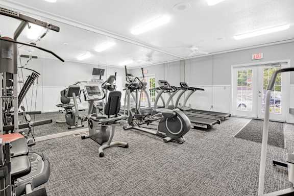 A gym with treadmills, elliptical machines, and other exercise equipment. at Kimberly Club Apartments, Davenport, Iowa