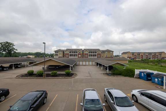 A parking lot with cars and a building in the background.
