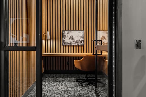 A room with a chair and a picture on the wall.