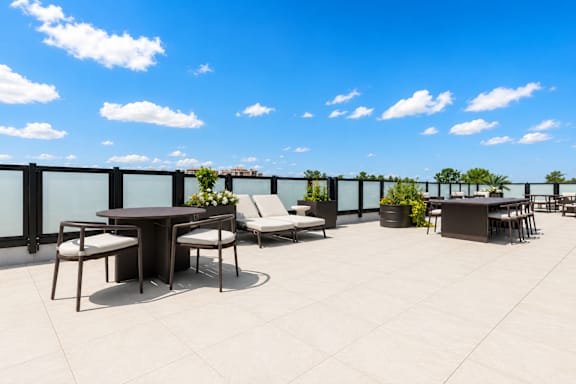 A patio with a table and chairs overlooking a cityscape.