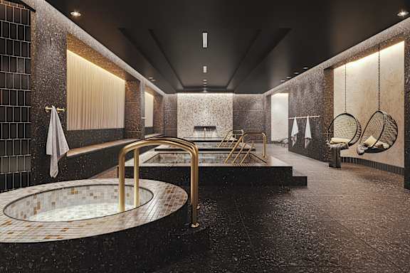A modern bathroom with a round gold-framed tub in the center.