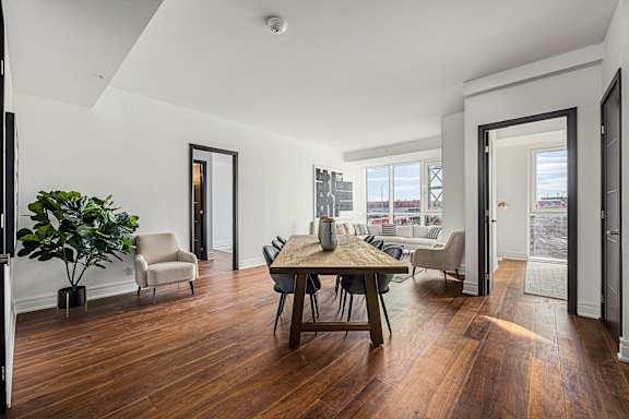 A room with a wooden floor and a table with chairs.