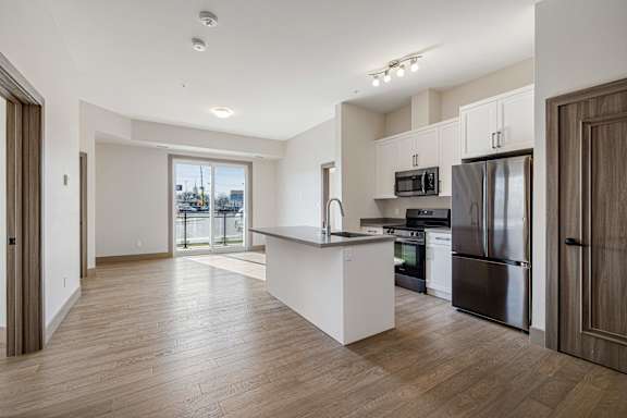 A kitchen with a refrigerator, oven, and microwave.