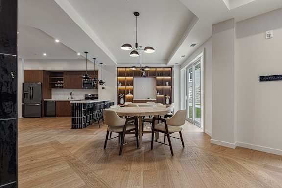 A modern dining room with a wooden table and chairs.