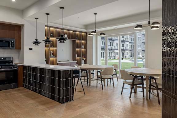 A modern kitchen with a large island and a dining table set up.