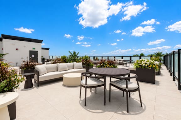 A patio with a table and chairs overlooking a body of water.