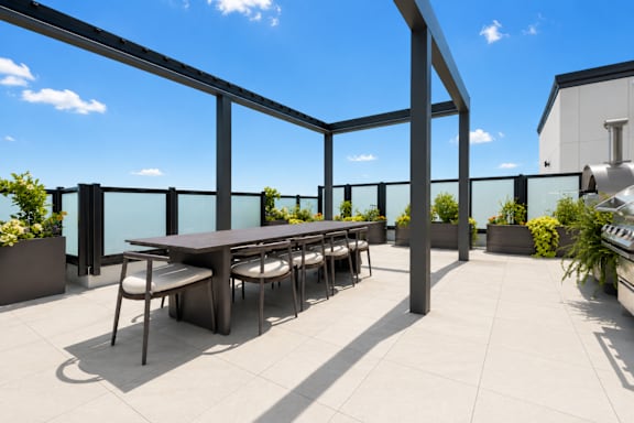 A table surrounded by chairs on a patio.