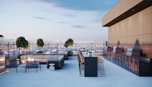A rooftop patio with a fire pit and seating area.