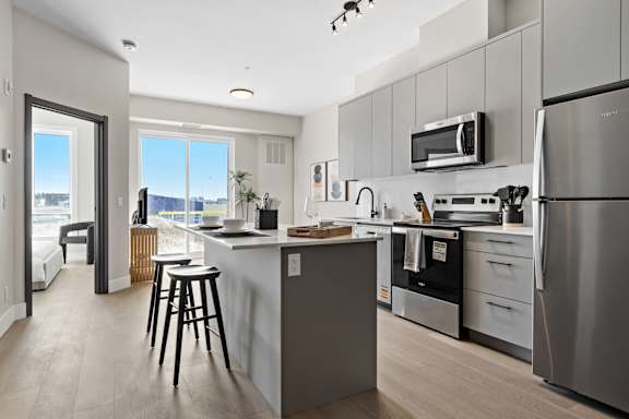 A modern kitchen with stainless steel appliances and a large island.