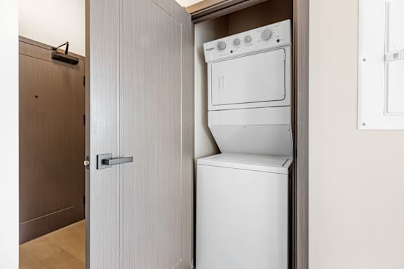 A white dishwasher and oven are built into a cabinet in a kitchen.
