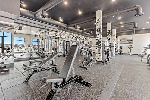 A gym with a variety of equipment including weights and machines.