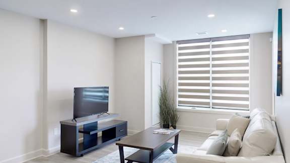 A modern living room with a flat screen TV and a sofa.