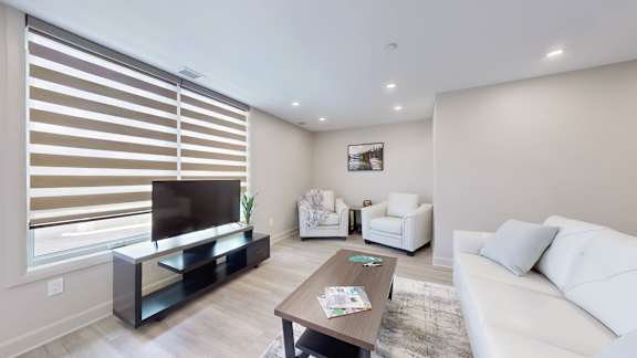 A modern living room with a flat screen TV and a white couch.