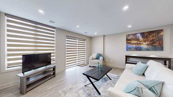 A modern living room with a flat screen TV and a coffee table.