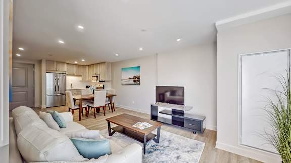 A modern living room with a white couch and a wooden coffee table.