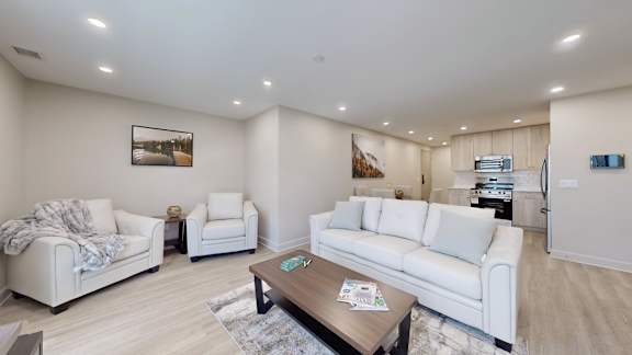 A living room with white furniture and a coffee table.