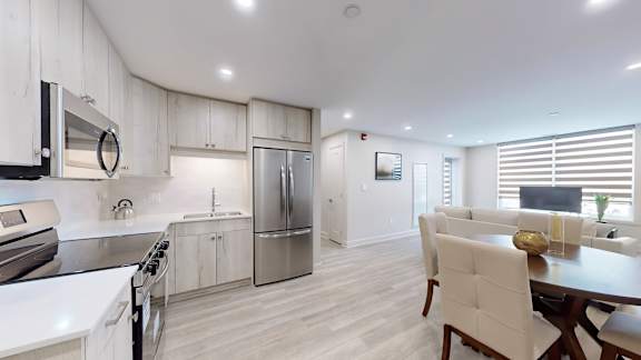 A modern kitchen with white cabinets and stainless steel appliances.