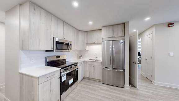 A modern kitchen with stainless steel appliances and wooden cabinets.