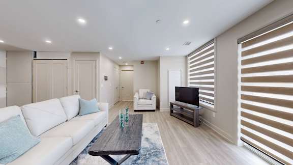 A modern living room with a white couch and a wooden coffee table.