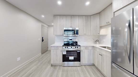 A modern kitchen with stainless steel appliances and white cabinets.