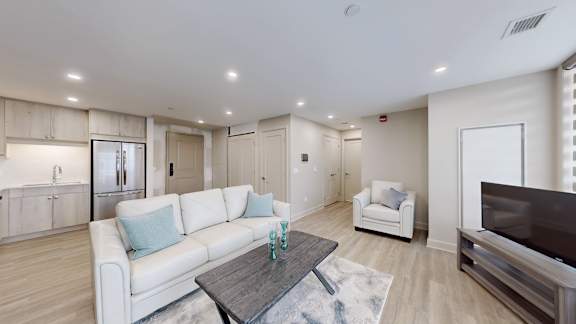 A modern living room with a white couch and a wooden coffee table.