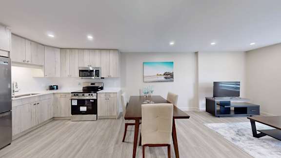 A modern kitchen with a dining table and chairs.