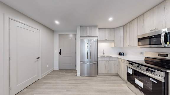 A kitchen with stainless steel appliances and wooden cabinets.